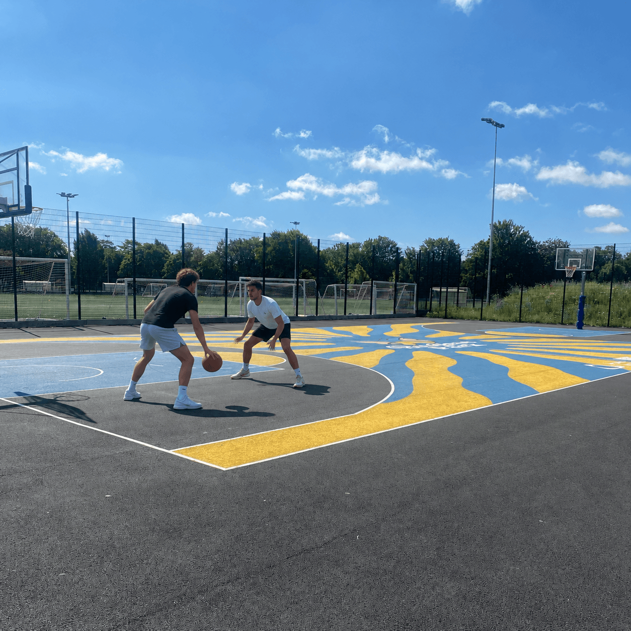 Two players going one-on-one on a local basketball court